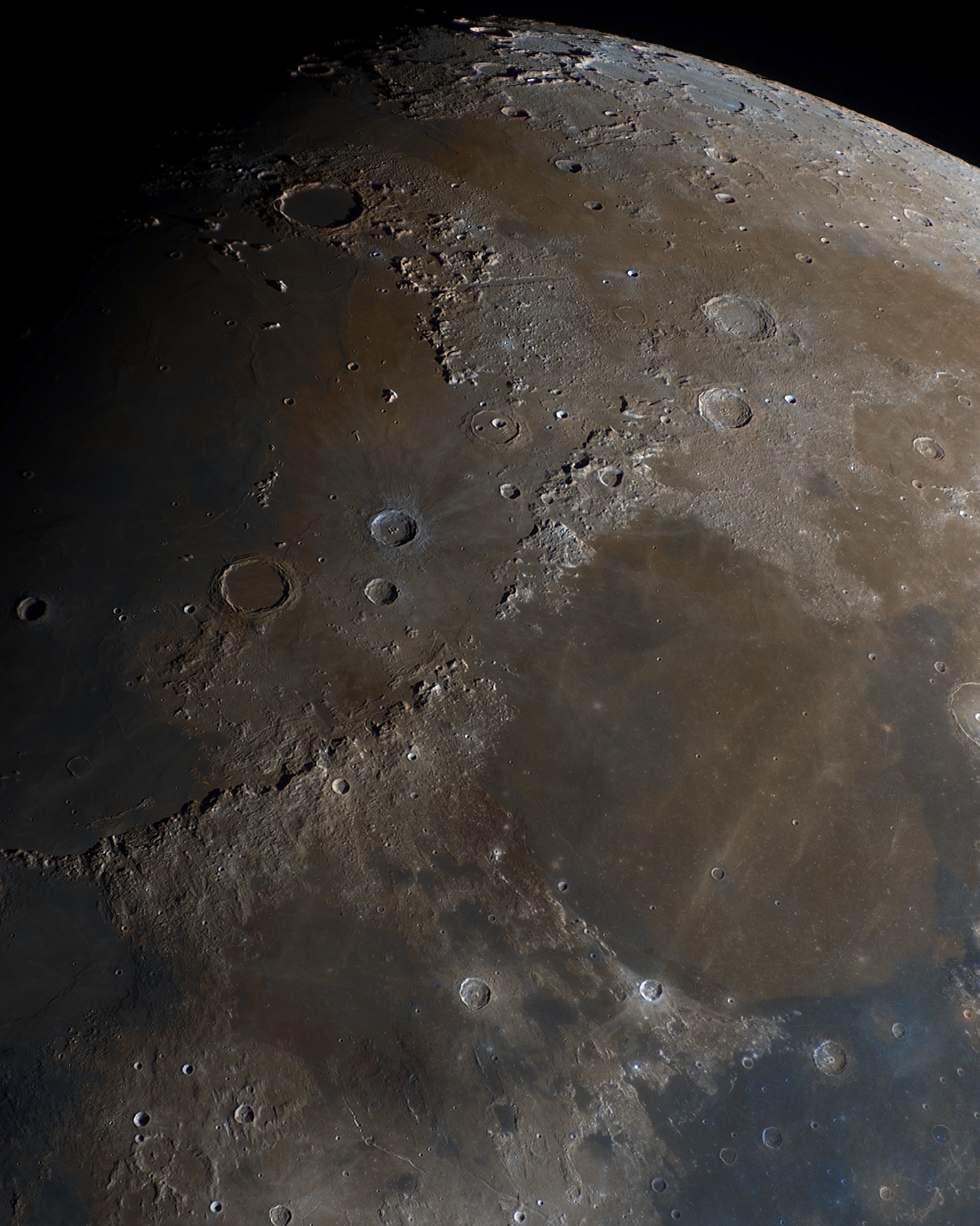 A stunning photo of the moon showing the maria in a series of dark browns and blues A stunning photo of the moon showing the maria in a series of dark browns and blues